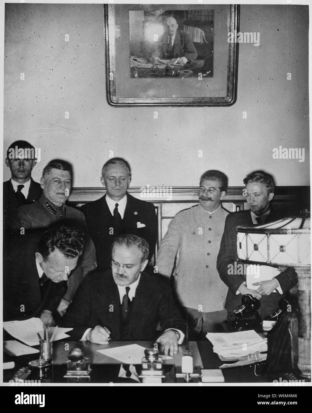 Soviet Foreign Minister Molotov signs the German-Soviet Boundary and Friendship Treaty; Joachim von Ribbentrop and Josef Stalin stand behind him, Moscow, September 28. 1939. Von Ribbentrop Collection., ca. 1946 - ca. 1946   Original incorrect title:   Soviet Foreign Minister Molotov signs the German-Soviet non-aggression pact; Joachim von Ribbentrop and Josef Stalin stand behind him, Moscow, August 23. 1939. Von Ribbentrop Collection., ca. 1946 - ca. 1946; General notes:  Use War and Conflict Number 990 when ordering a reproduction or requesting information about this image. Stock Photo