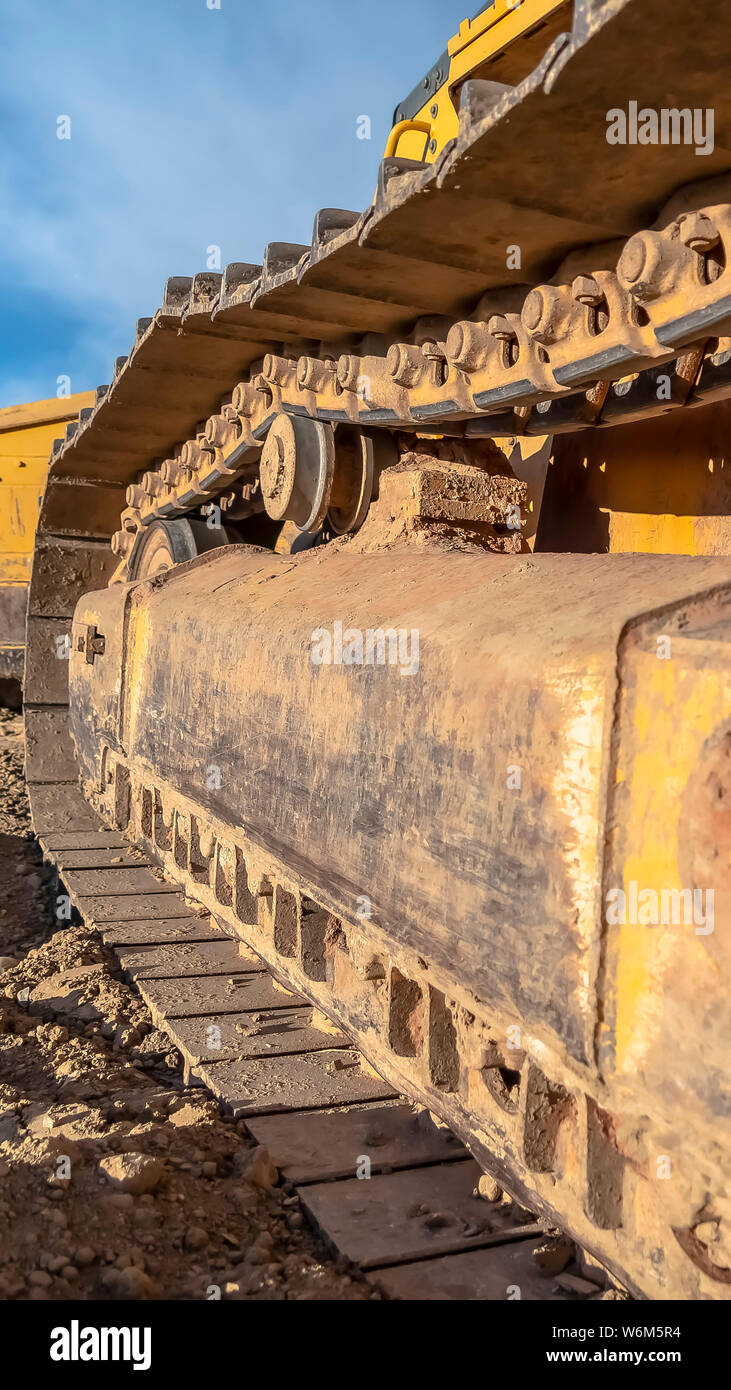 Vertical frame Excavator with close up of the dirty metal track frame