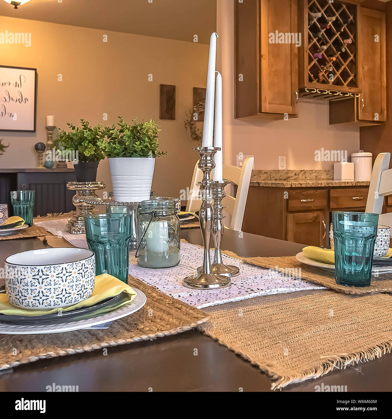 Square White chairs around a brown dining table with hemp table runners