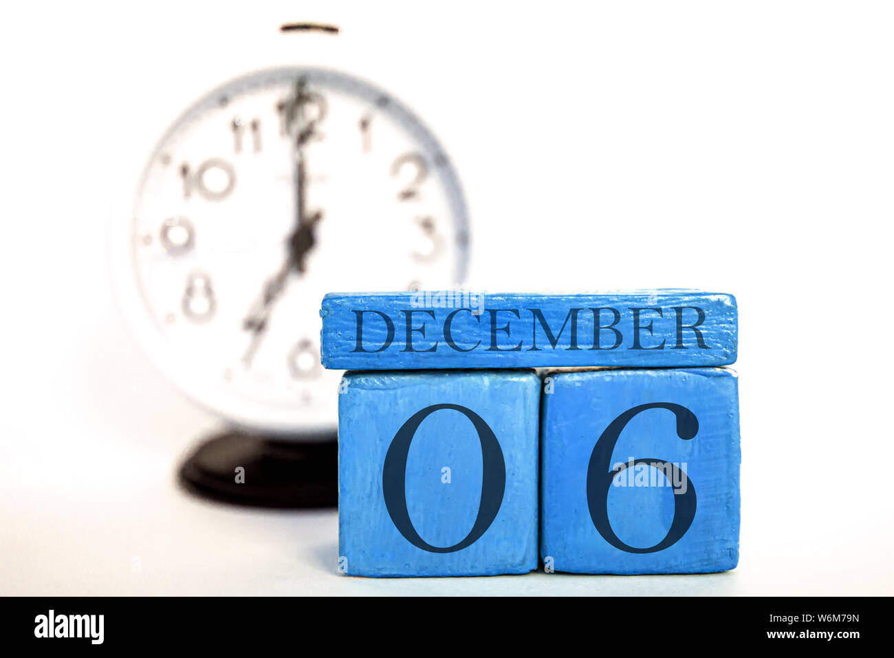 december 6th. Day 6 of month, handmade wood cube calendar and alarm clock on  blue color. winter month, day of the year concept. Stock Photo