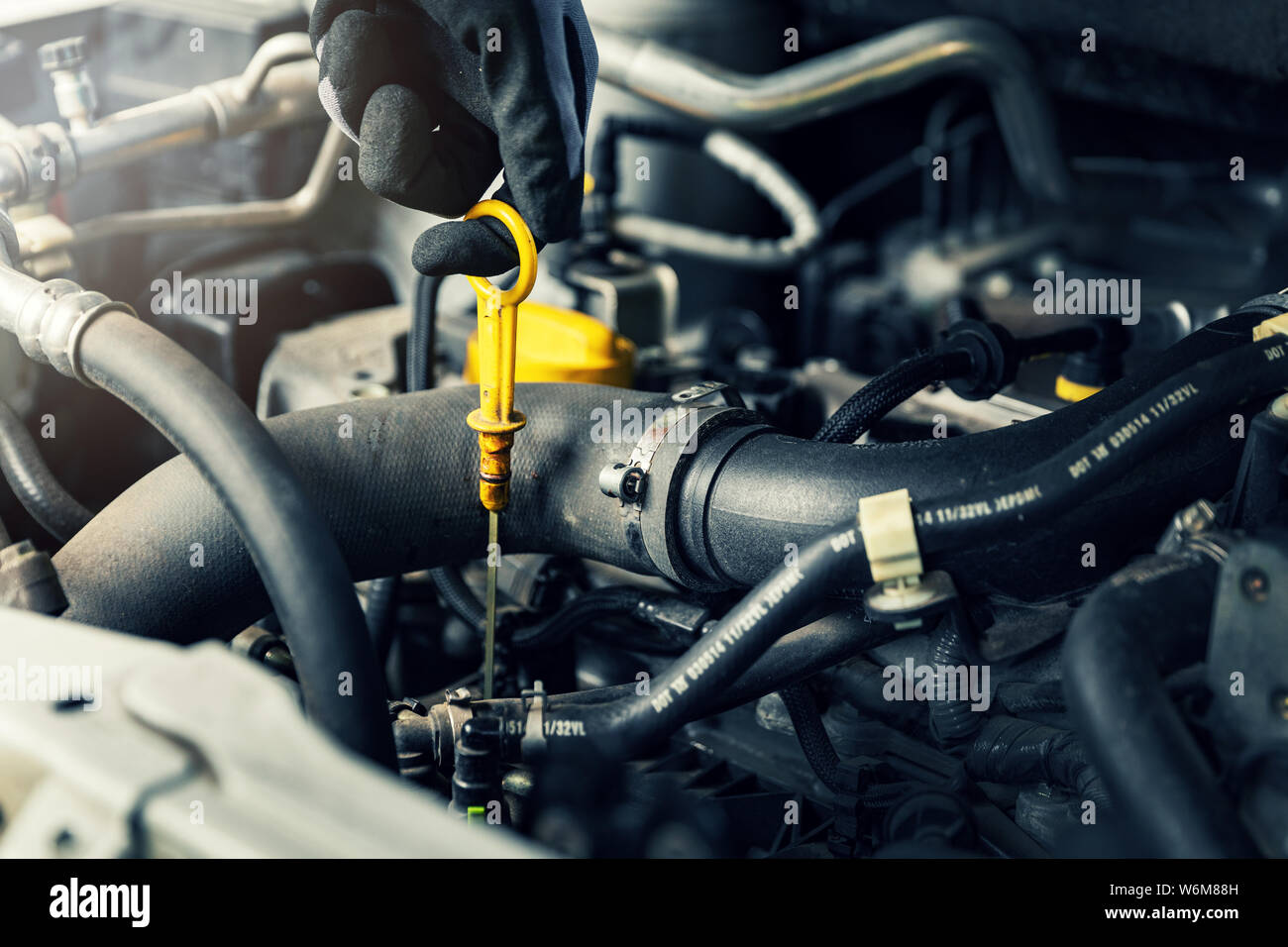 hand pulling out car engine oil level dip stick closeup Stock Photo Alamy