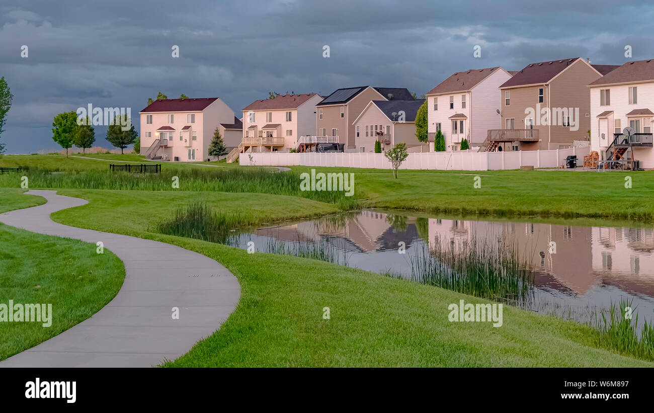 Panorama Park pathway and pond with bridge in front of houses with