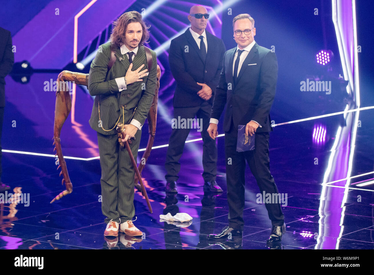 Cologne, Germany. 02nd Aug, 2019. Musician Gil Ofarim (l) stands on stage as 'grasshopper' at the ProSieben show 'The Masked Singer' next to presenter Matthias Opdenhövel (r). Credit: Marcel Kusch/dpa/Alamy Live News Stock Photo