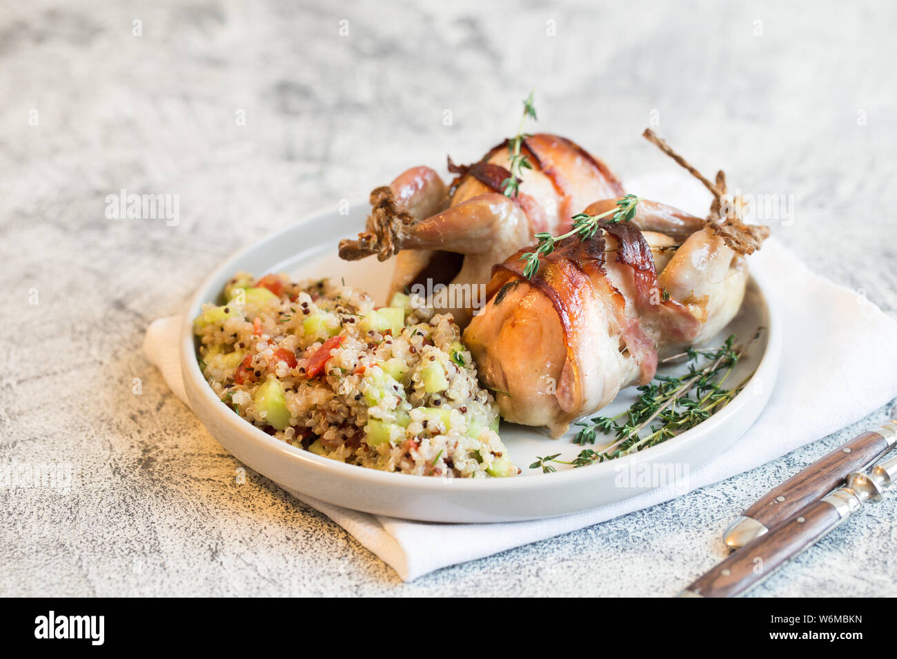 delicious baked quail with bacon and side dish Stock Photo Alamy