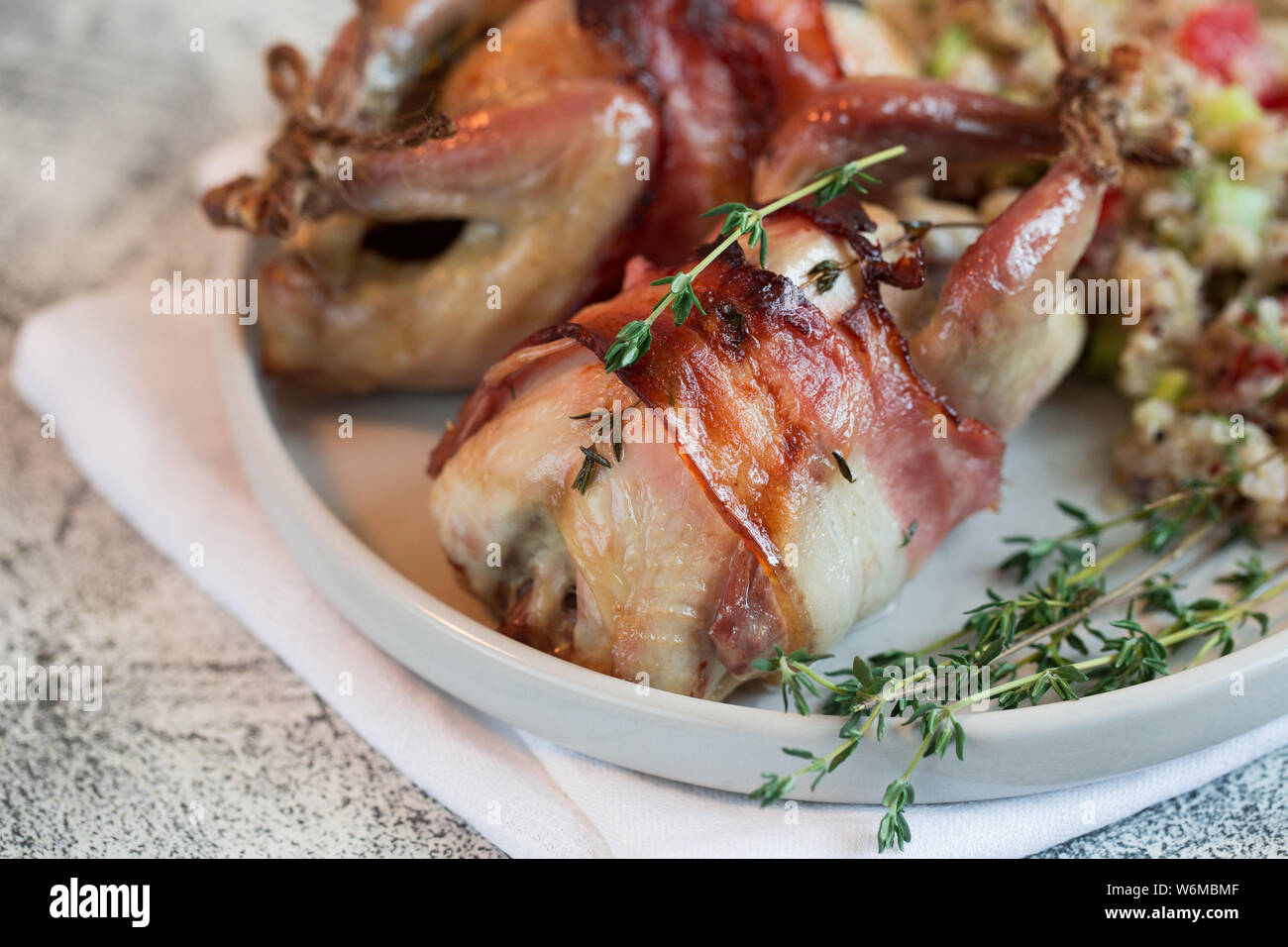 delicious baked quail with bacon and side dish Stock Photo Alamy