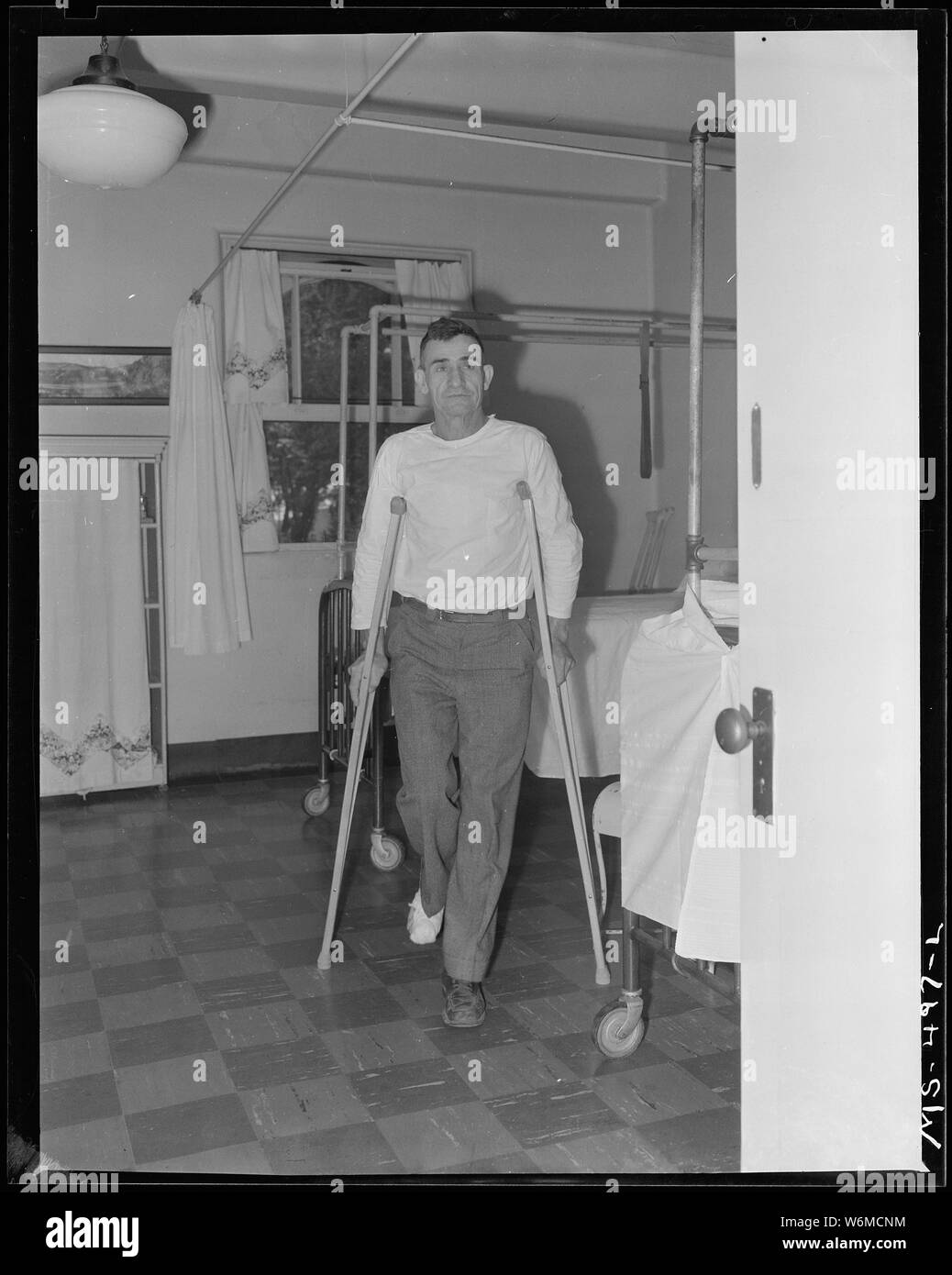 Telesfro Deluna, miner, walking on crutches. He is recovering from foot injured in mine accident. He has received medical care at this company owned hospital. Colorado Fuel & Iron Company, Pueblo, Colorado. Stock Photo