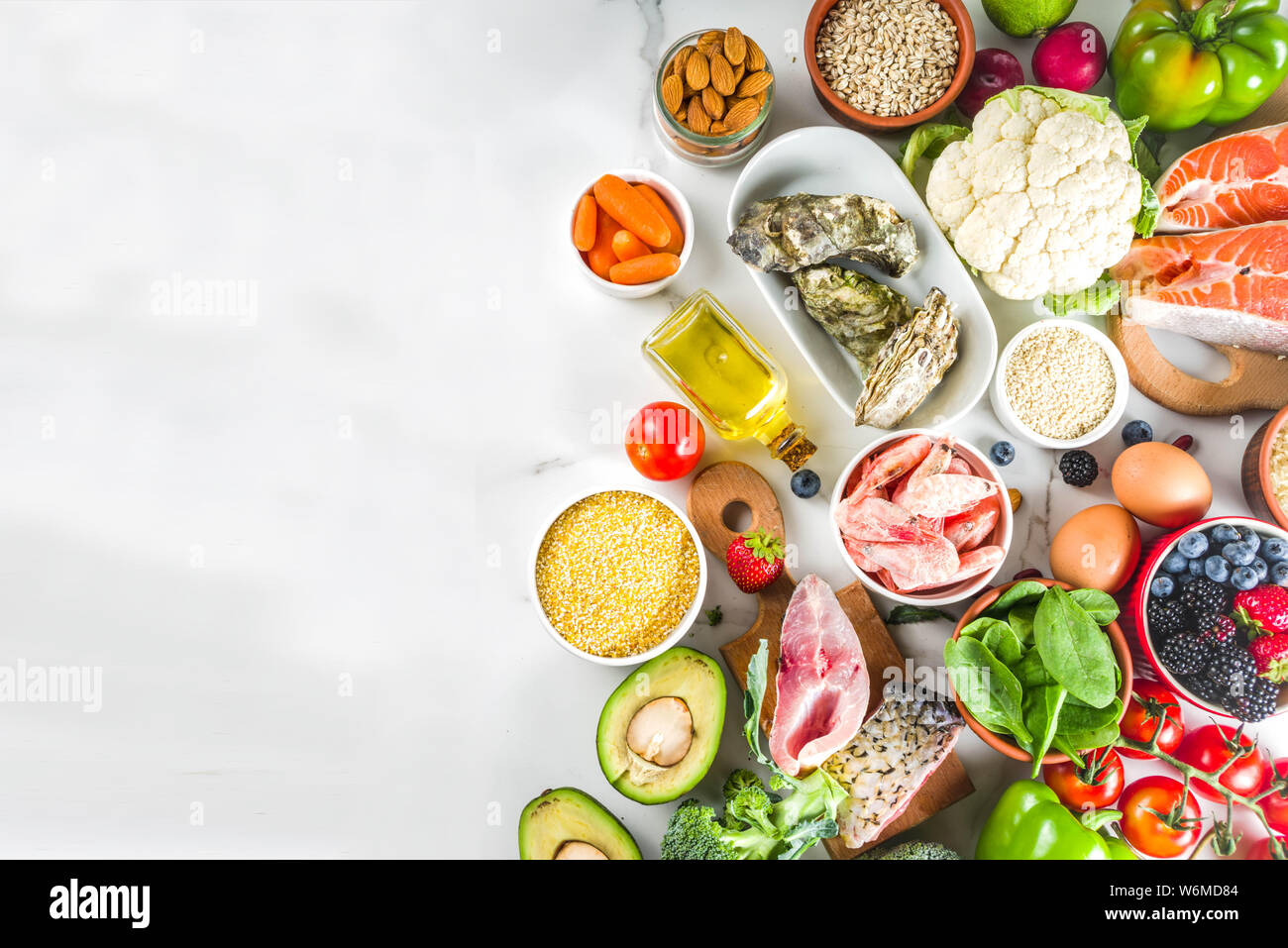 Pescetarian diet plan ingredients, healthy balanced grocery food, fresh fruit, berries, fish and shellfish clams, white marble background copy space Stock Photo