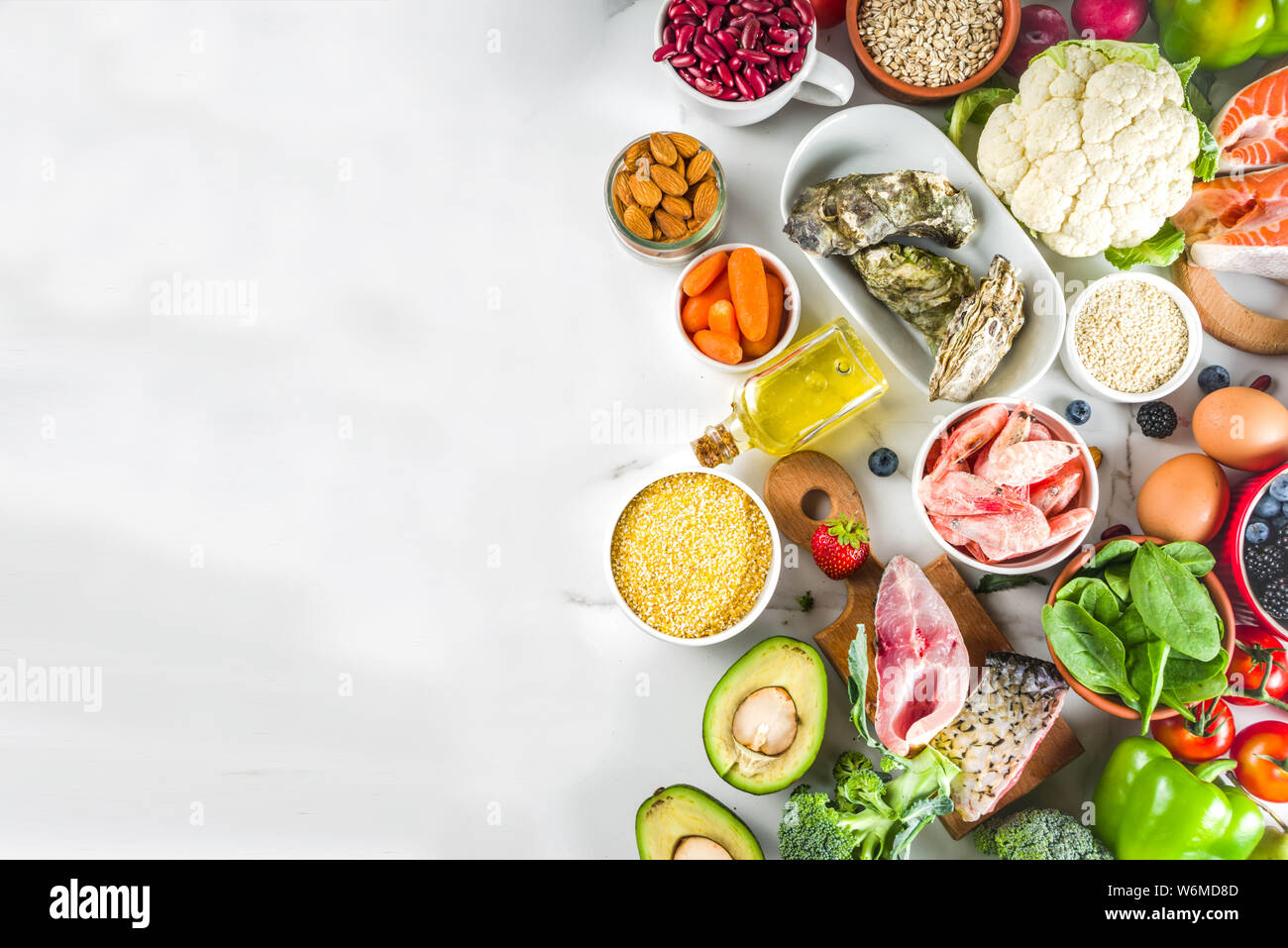 Pescetarian diet plan ingredients, healthy balanced grocery food, fresh fruit, berries, fish and shellfish clams, white marble background copy space Stock Photo