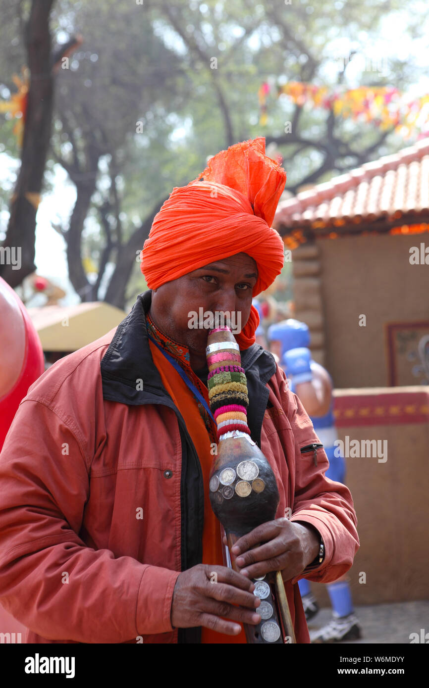 Snake charmer playing pungi at Surajkund Crafts Mela, Surajkund