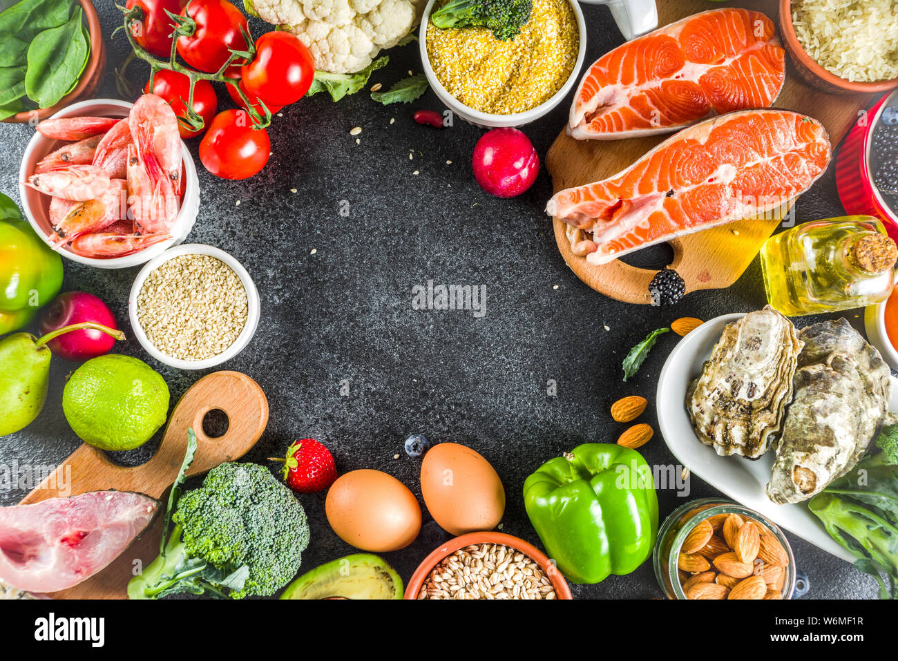 Pescetarian diet plan ingredients, healthy balanced grocery food, fresh fruit, berries, fish and shellfish clams, black stone concrete background copy Stock Photo