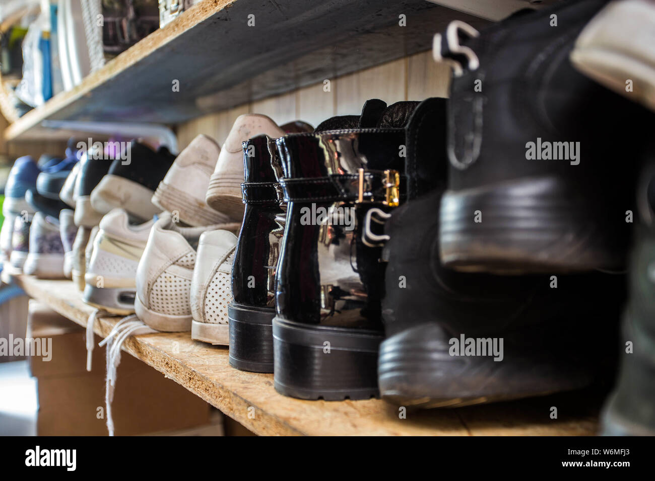 Small shoe rack fully filled with many shoes, sneakers and sandals. Too many shoes make the shoe rack messy. Getting a better furniture will make your Stock Photo