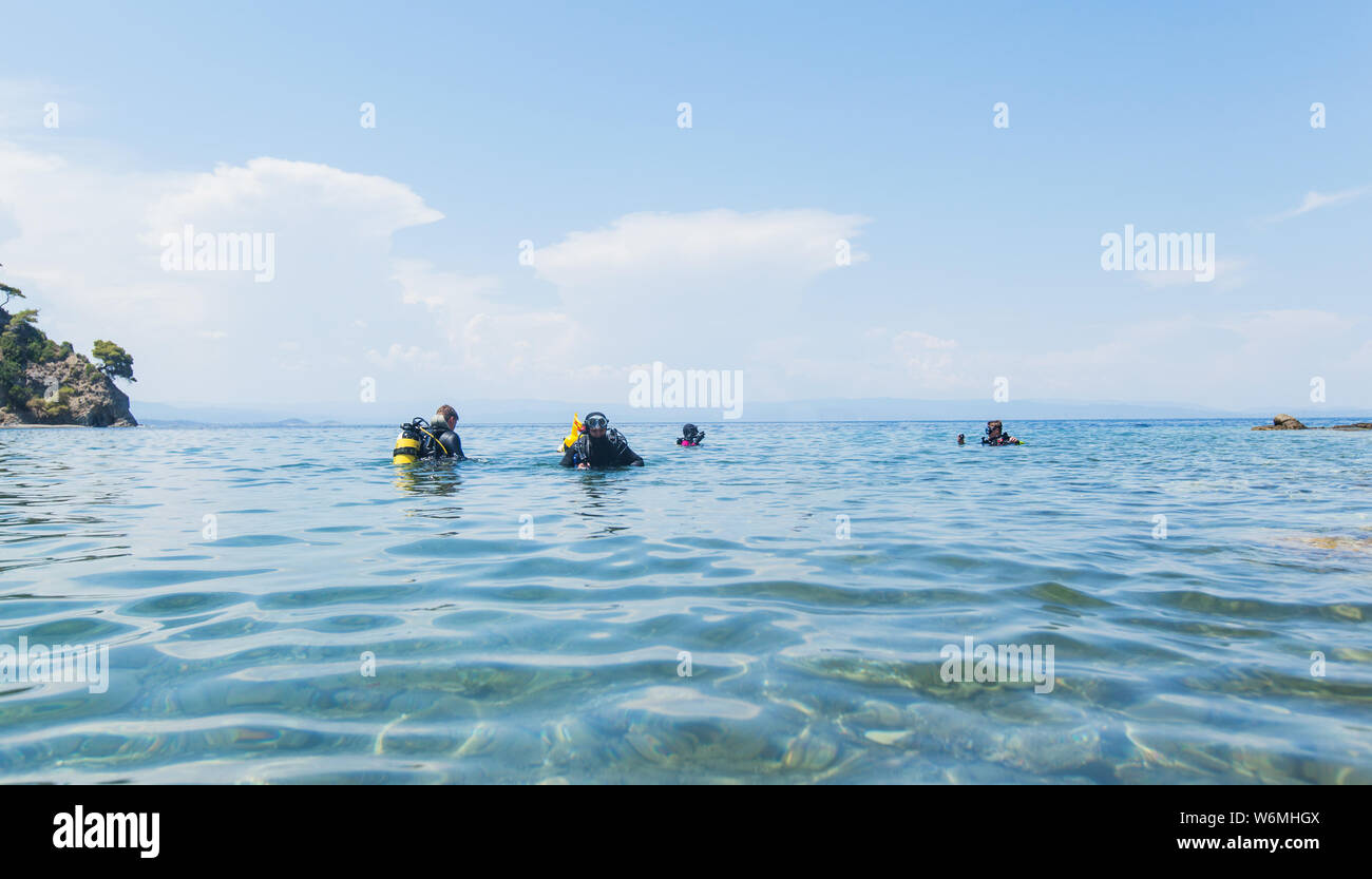 Group of scuba divers ready for diving in the beautiful Greece turquoise sea. Summer holiday