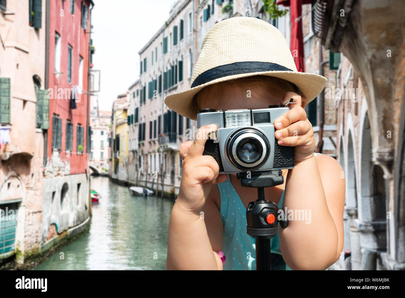 Portrait Of A Little Girl Standing Over Bridge Taking Picture Through Camera In Venice Stock Photo