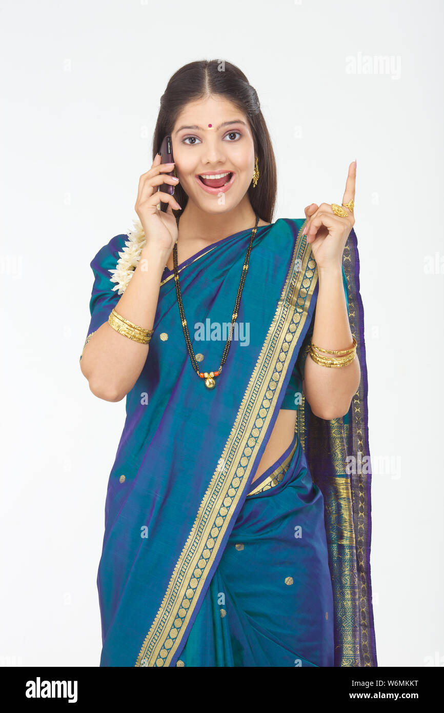 South Indian woman talking on mobile phone and pointing Stock Photo - Alamy
