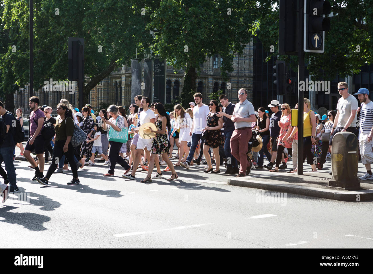 People crossing road, with Natural History Museum in background, South Kensington, London, SW7. The human race. Pensions. Life insurance. Contagion. Stock Photo