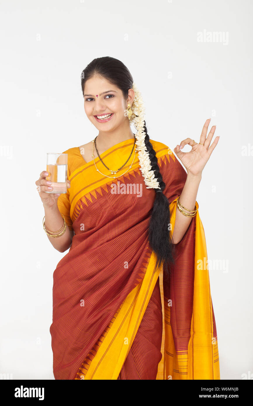 South Indian Woman Holding Glass Of Water And Showing Ok Sign Stock