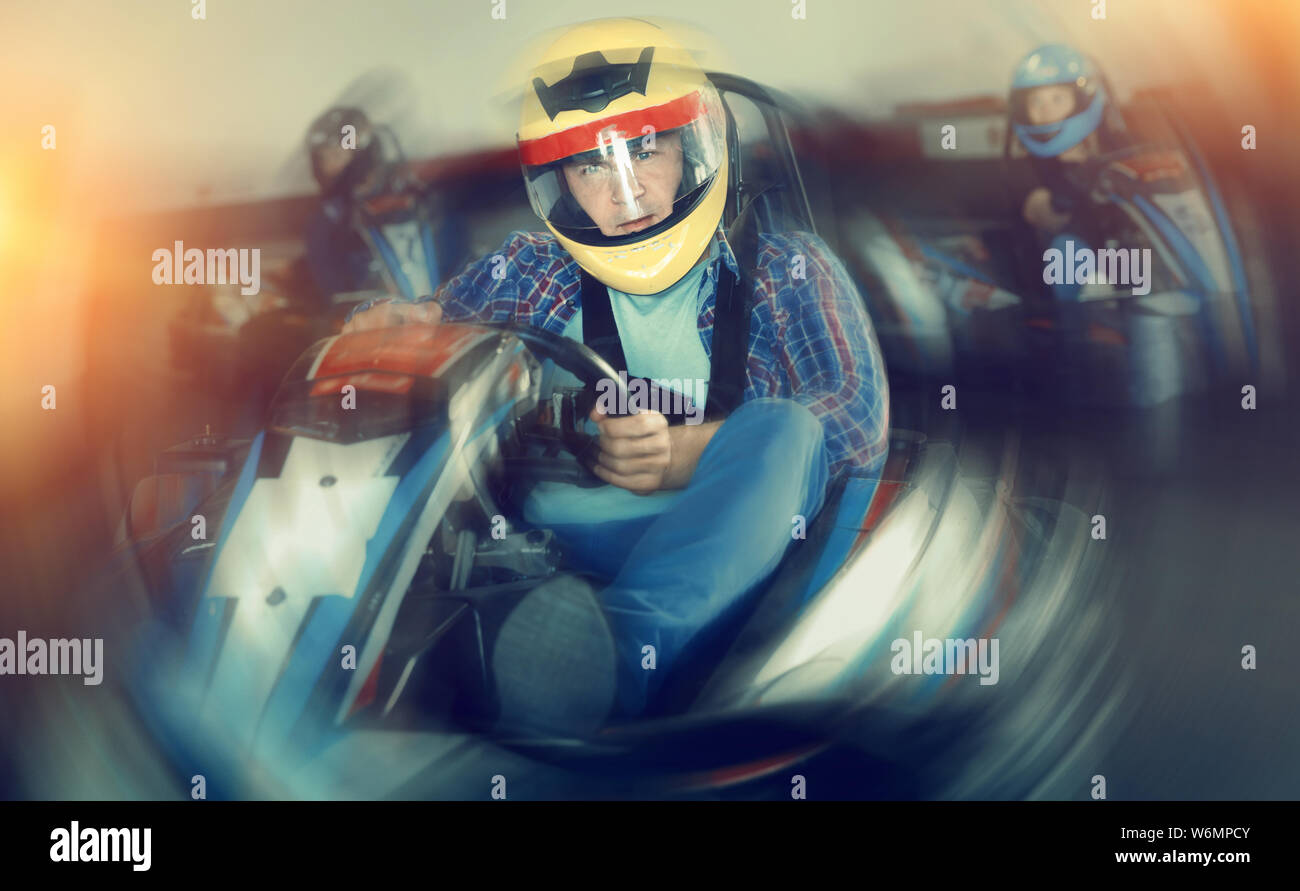 Happy Racing Rider Portrait of happy positive smiling male racer in helmet driving kart on ...