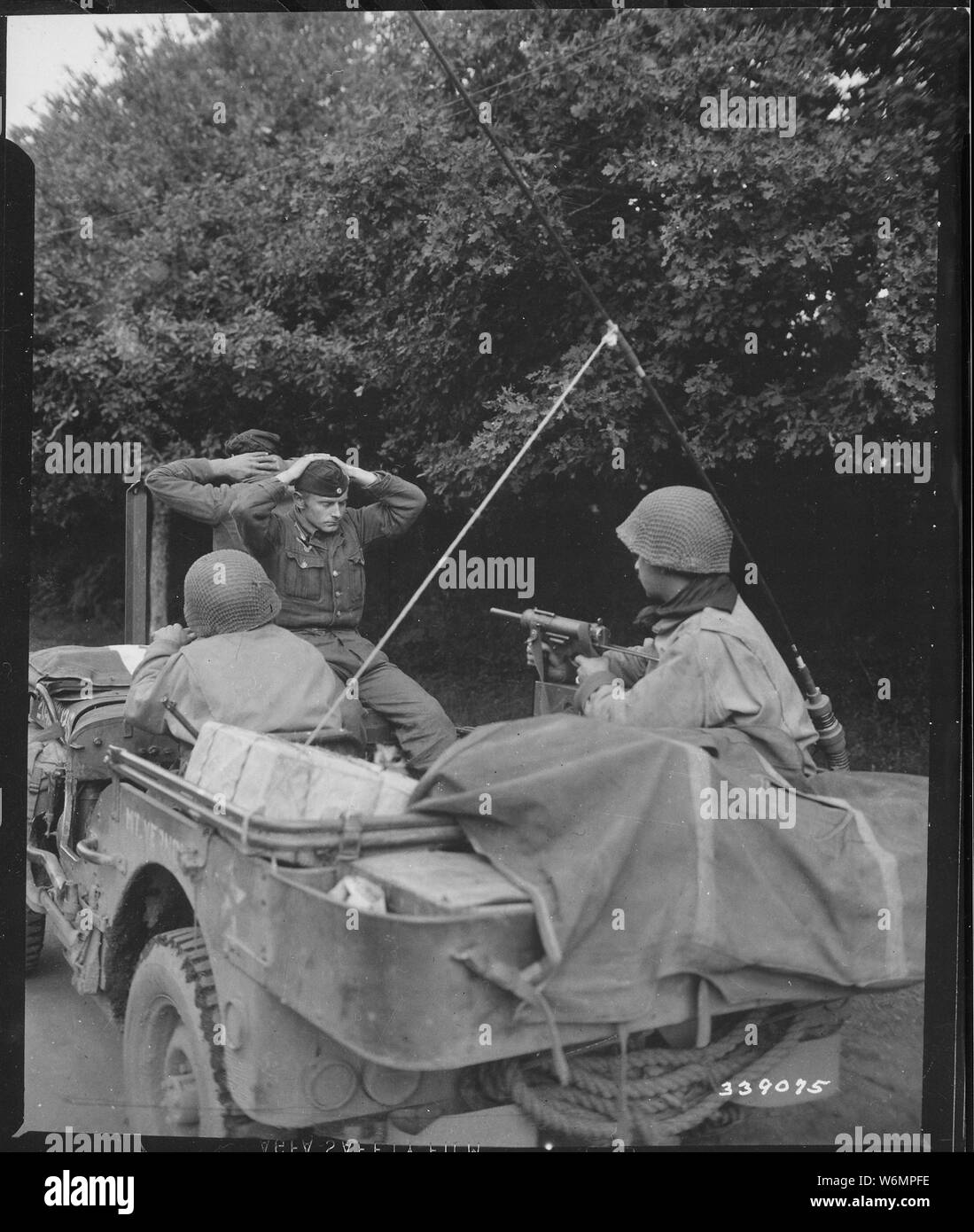 Two German prisoners of war are being taken to the 6th Division Prisoner of War Encampment for interrogation and searching. There were 218 captured by the Free French Infantry and 6th Armored Division troops. Plouay, France.; General notes:  Use War and Conflict Number 1284 when ordering a reproduction or requesting information about this image. Stock Photo