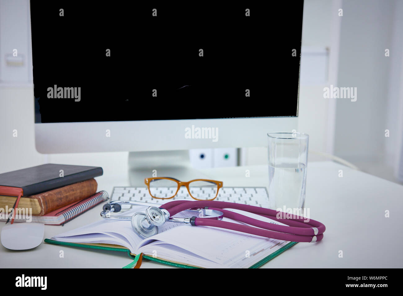Stethoscope lying on a table on an open book. Stock Photo