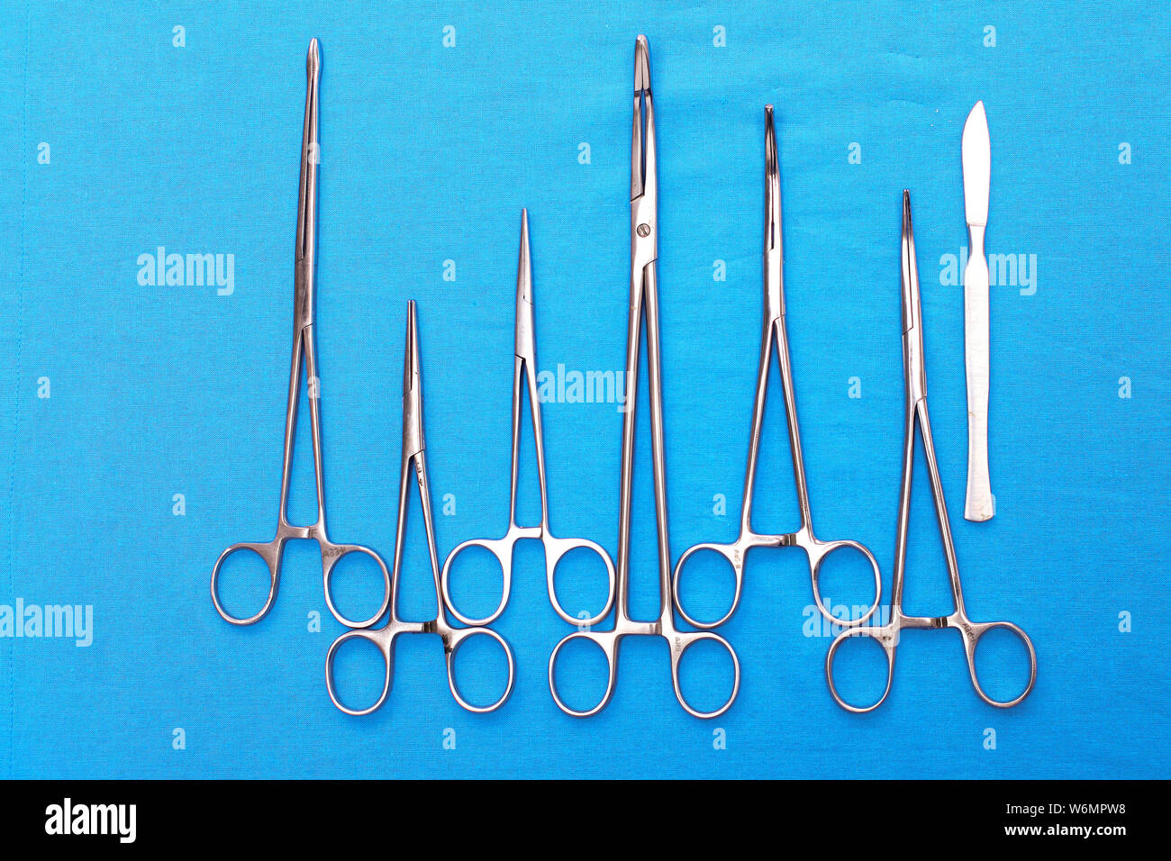 surgical instruments and tools including scalpels, forceps and tweezers arranged on a table for a surgery. Stock Photo