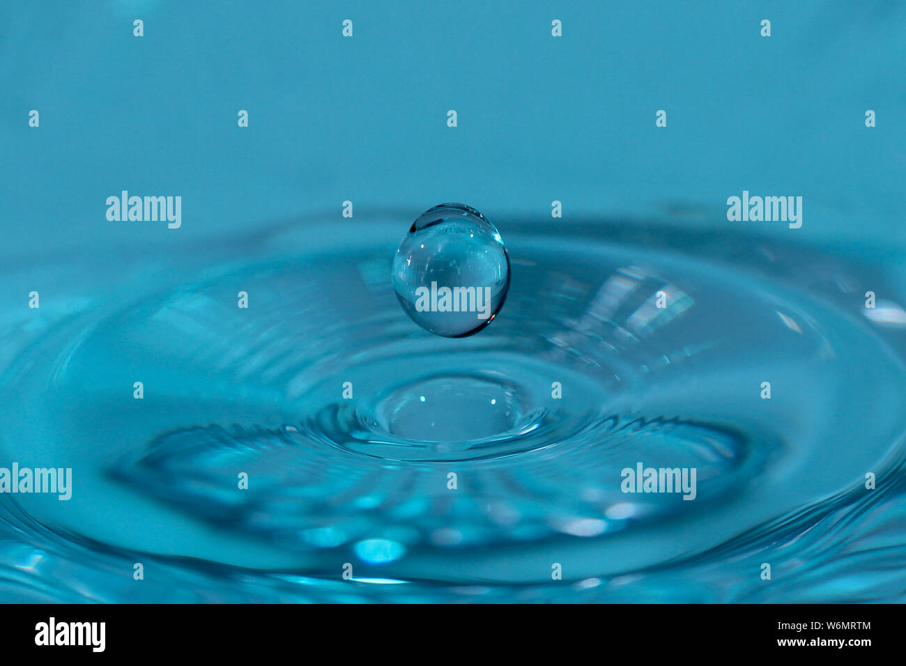 Texture, background with falling water drops and waves with blue water Stock Photo