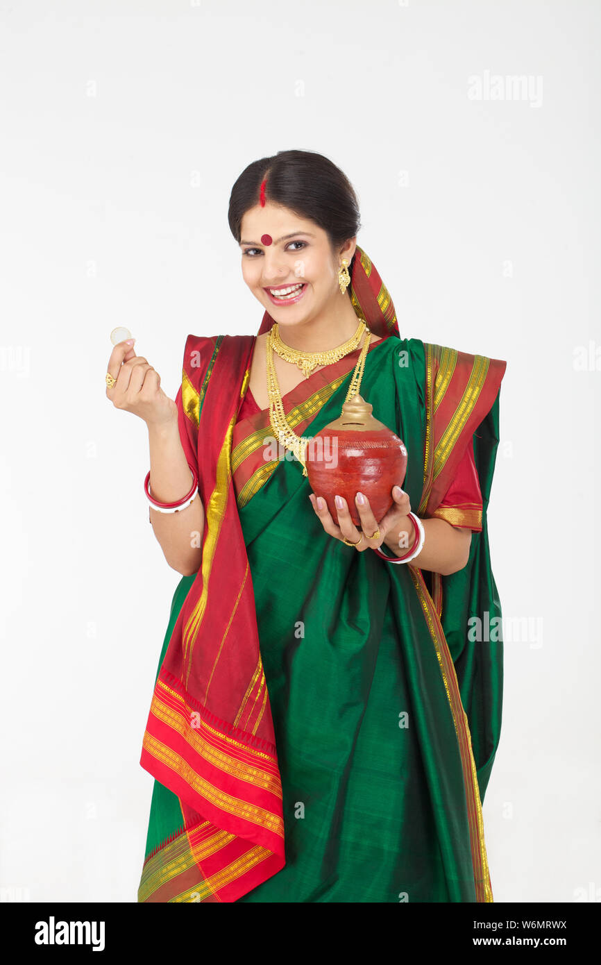 Bengali woman inserting a coin into a piggy bank Stock Photo Alamy
