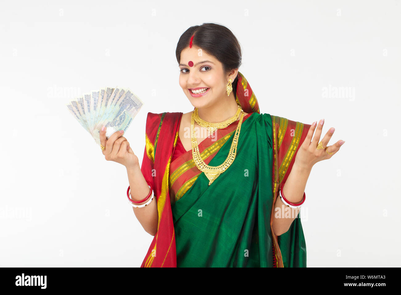 Bengali woman showing hundred rupees banknotes and smiling Stock Photo