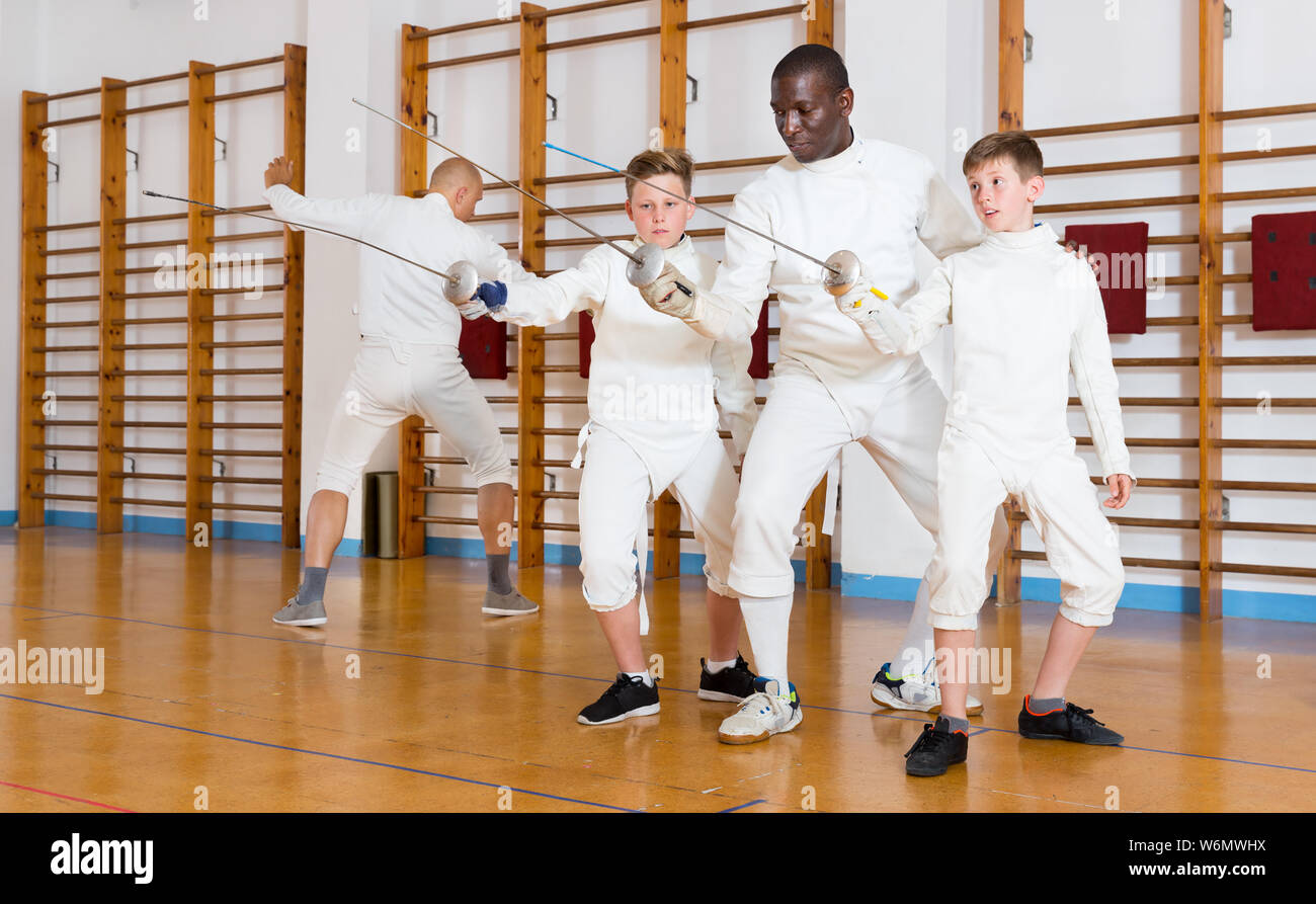 Fencing instructor explaining to young fencers effective movements and