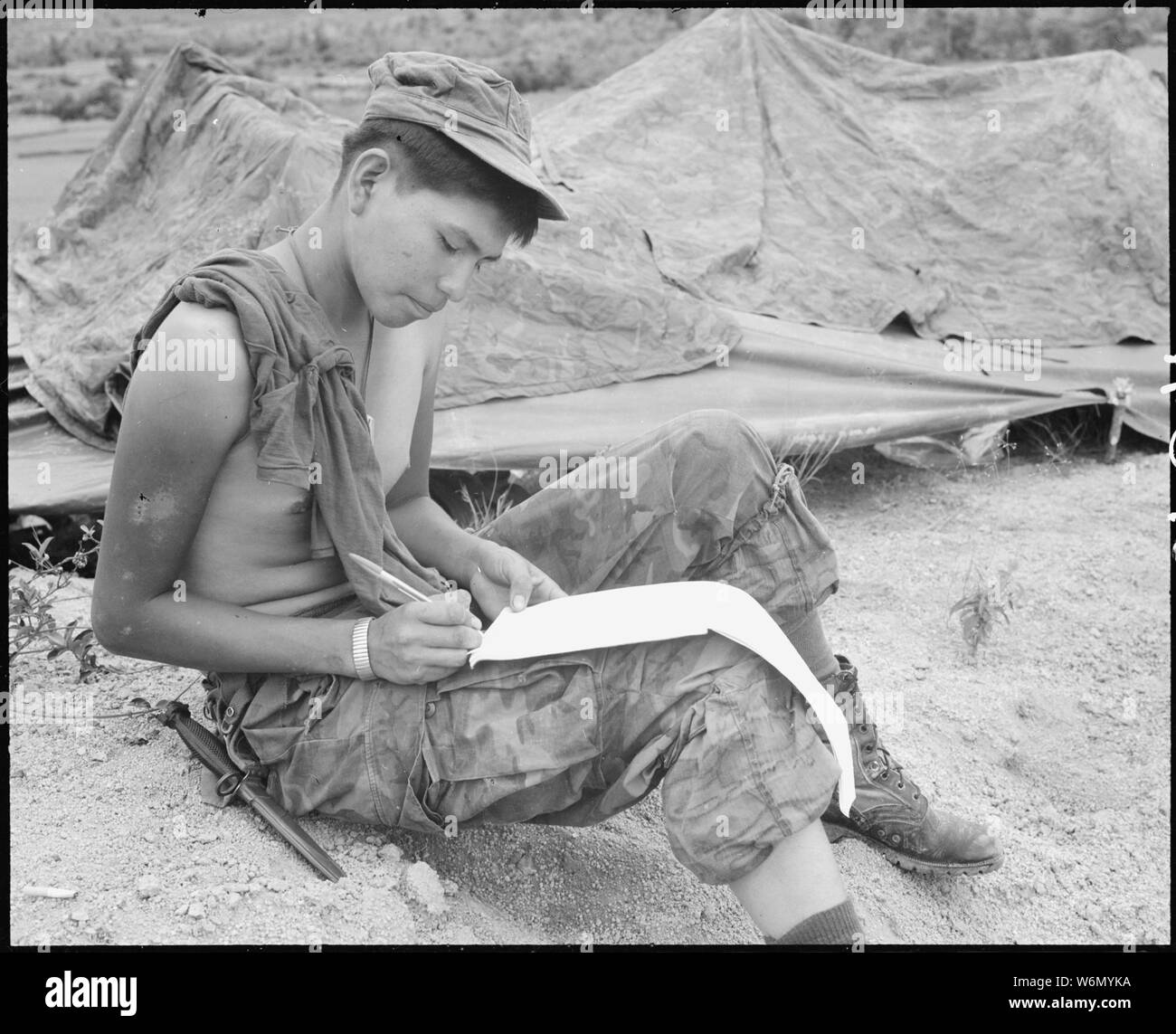 Vietnam....Private First Class Joseph Big Medicine Jr., a Cheyenne Indian, writes a letter to his family in the United States. He is a member of Company G, 2nd Battalion, 1st Marine Regiment, on a search, clear and destroy mission, seven miles east of the Marine Combat Base at An Hoa. Stock Photo