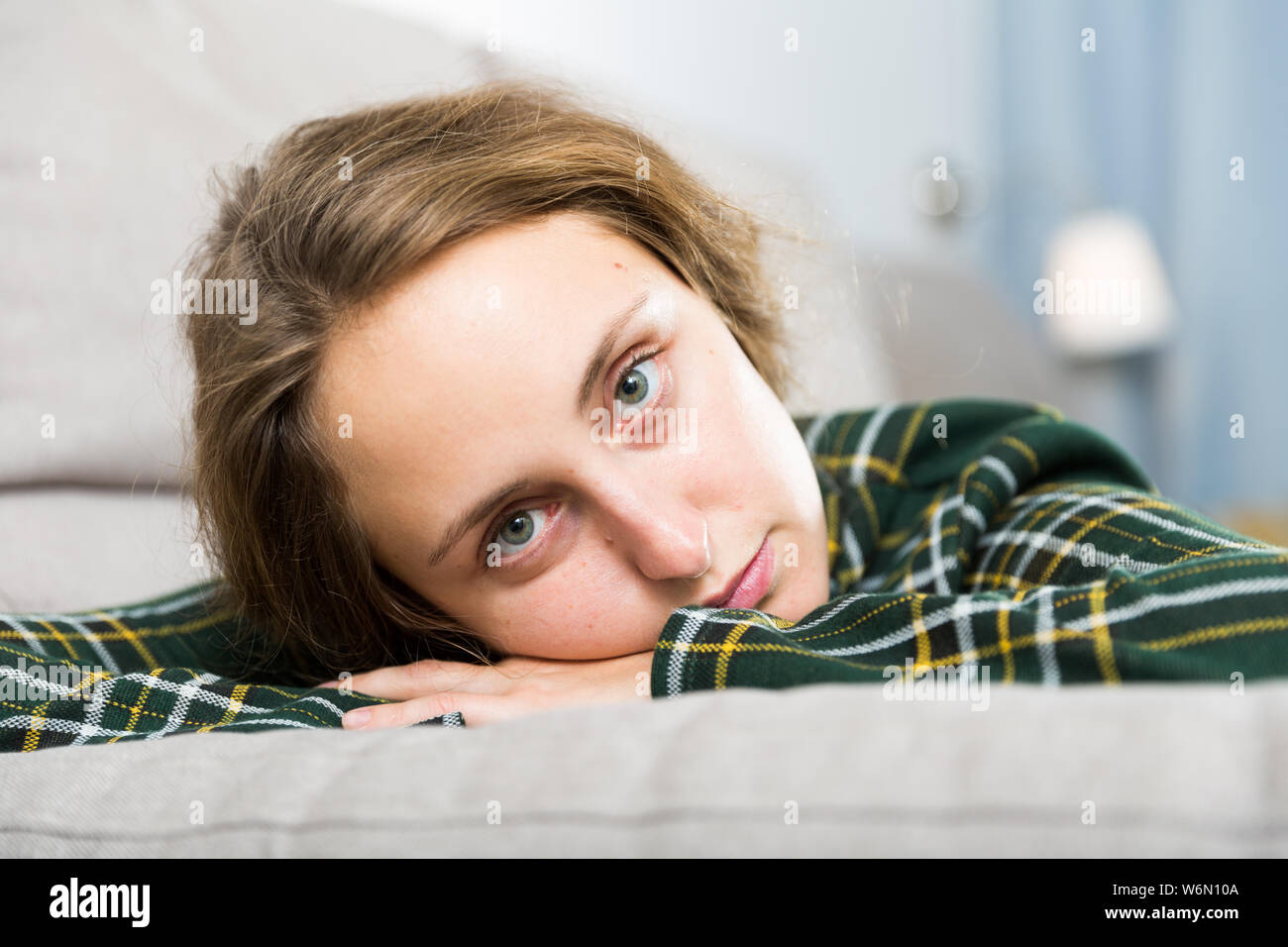 Portrait of sad girl sitting in living room at home Stock Photo - Alamy