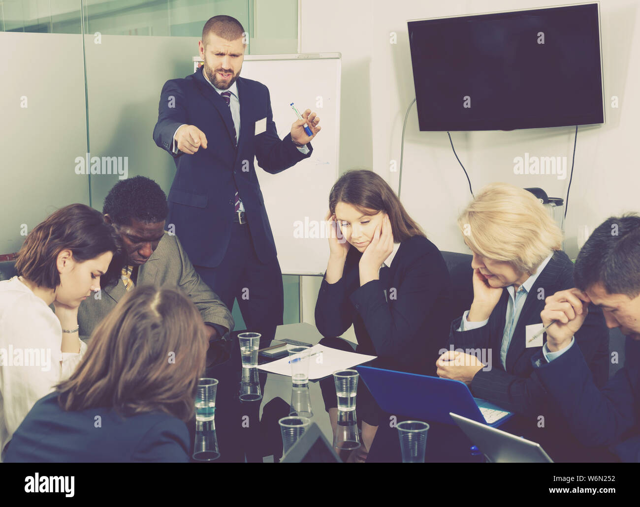 Angry boss berating his subordinates pointing out shortcomings and ...
