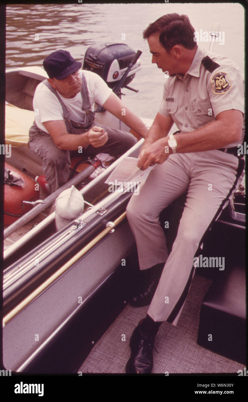 WATER PATROL SUPERVISOR DAN NEEDHAM ISSUES A WARNING TO FISHERMAN FOR FAILURE TO DISPLAY APPROPRIATE LICENSING ON THE BOW OF HIS BOAT. ENCOUNTERS BETWEEN THE WATER PATROL AND THE PUBLIC APPEAR TO BE HANDLED BOTH CORDIALLY AND PROFESSIONALLY Stock Photo