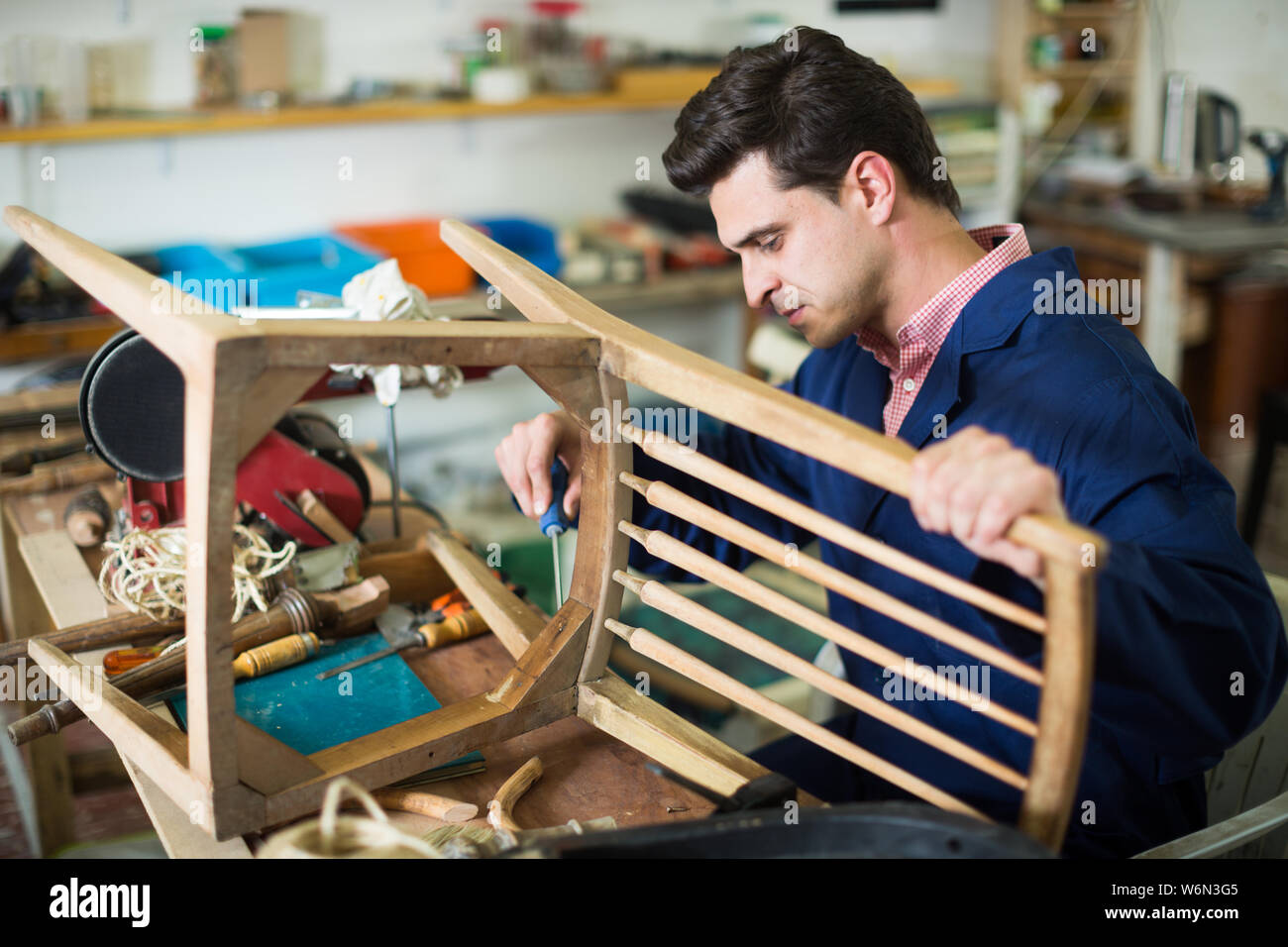 Carpenter working in repair studio and repairing broken wooden ...