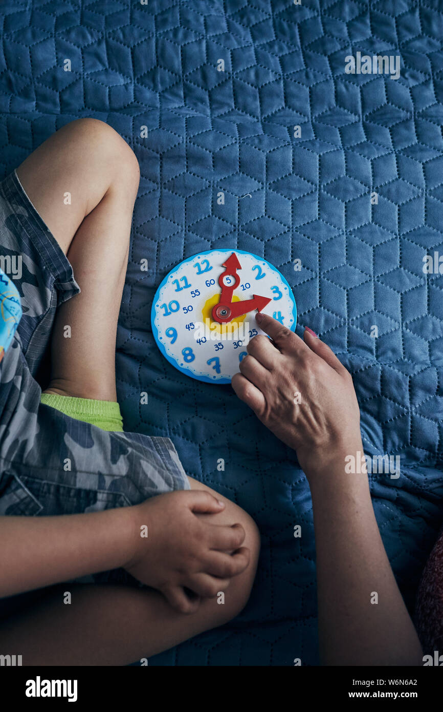 Kids learning how to tell time from clock and set the hands in the