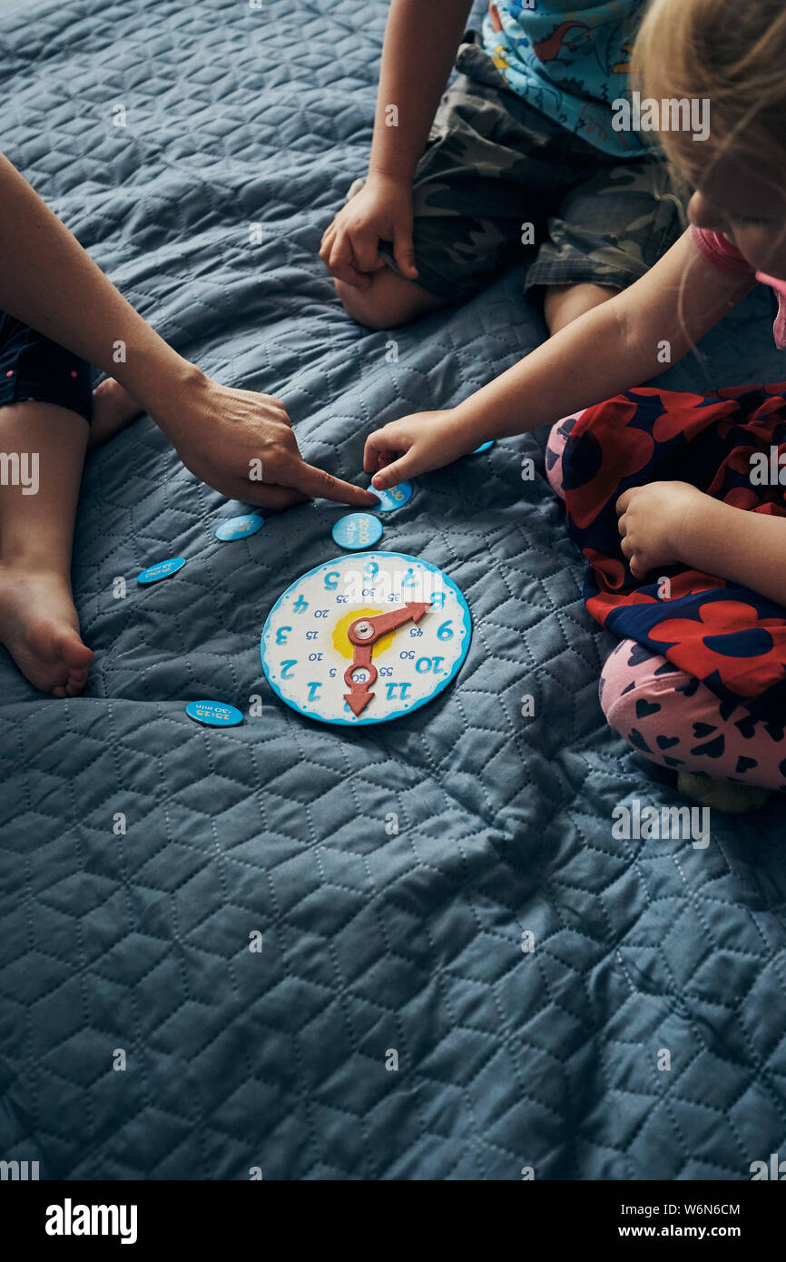 Kids learning how to tell time from clock and set the hands in the
