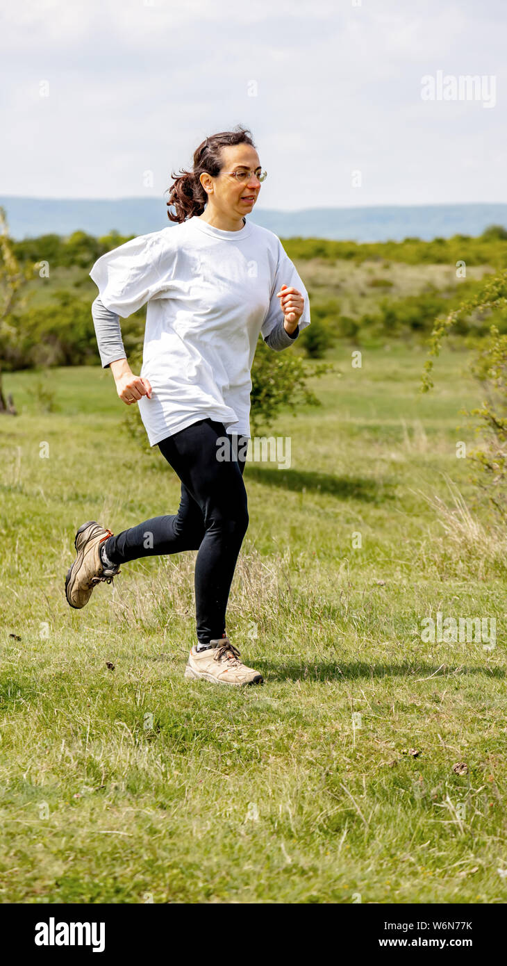 Spanish woman running on meadow Stock Photo Alamy