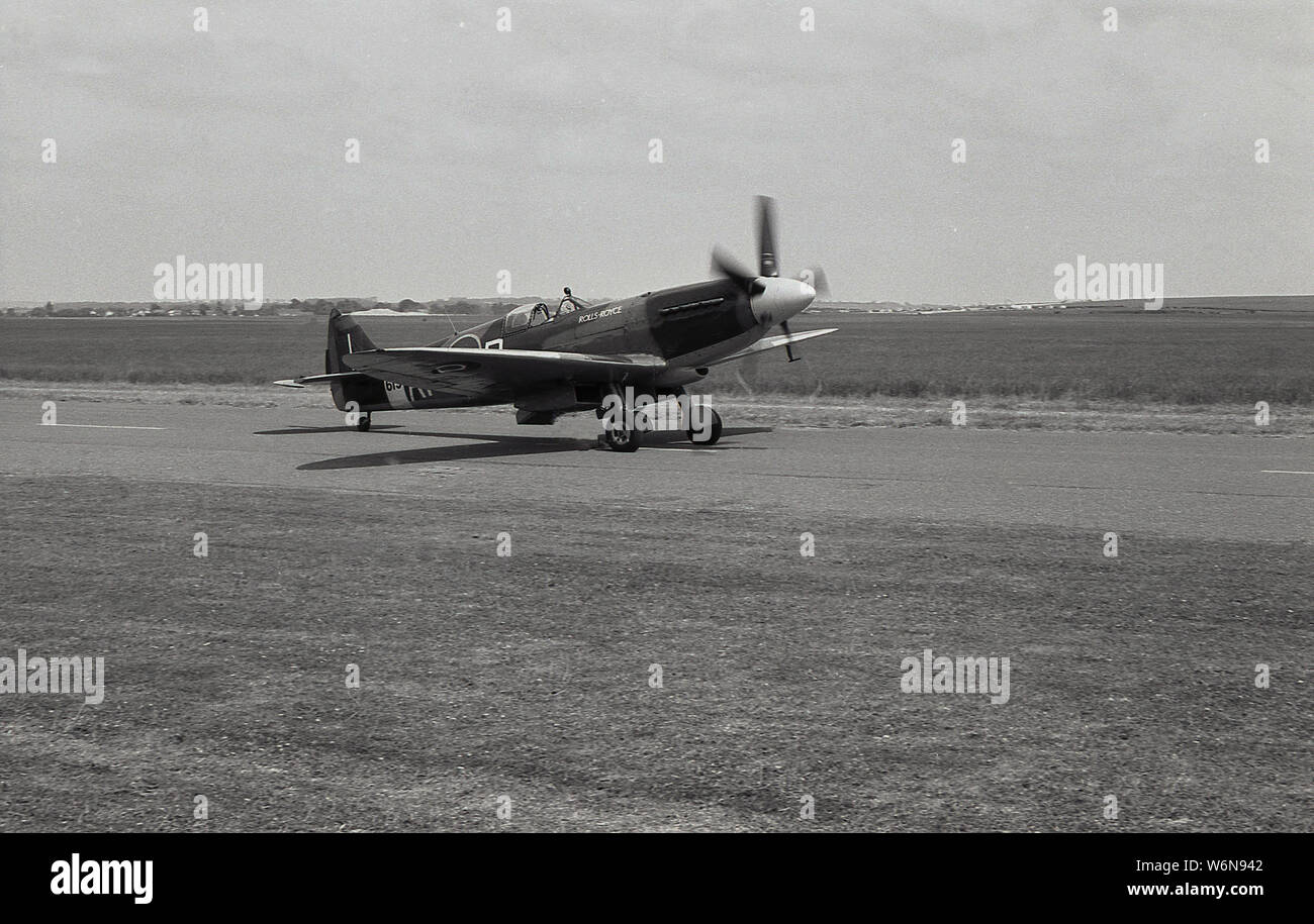 1970s, historical, a Spitfire aircraft on the runway at Duxford aerodrome, Cambridgeshire, England, UK. We see here a Spifire fighter airplane on the ruwway. Duxford was the base of the RAF during the First World War and was an important base for the Battle of Britain during WW2, remaining active unitl 1961. The site was given to the Imperial War Museumin 1976. Stock Photo