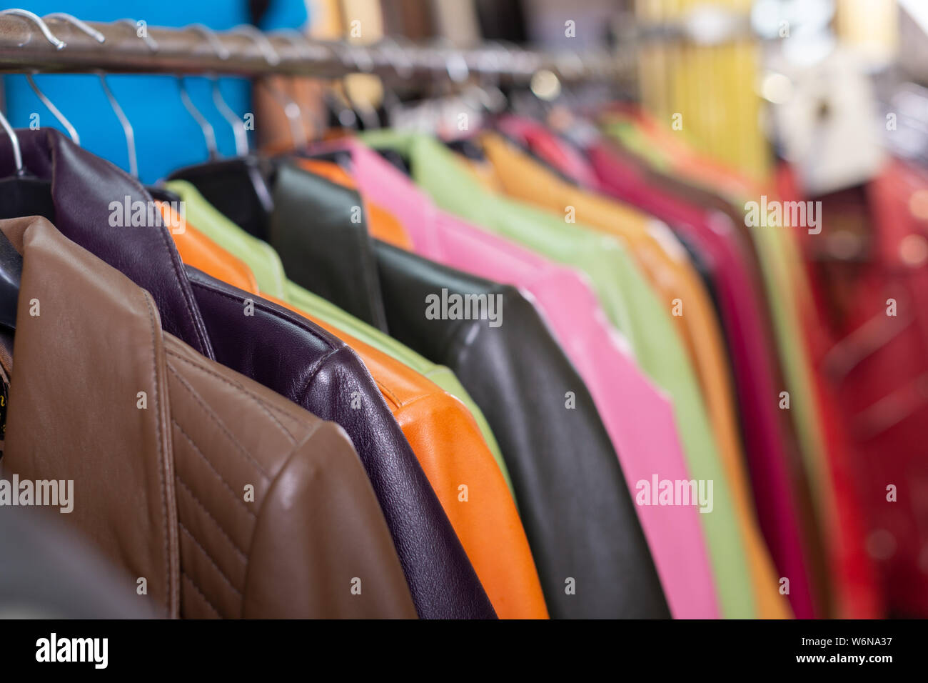 Variety of different leather jackets exposed on clothing racks in shop