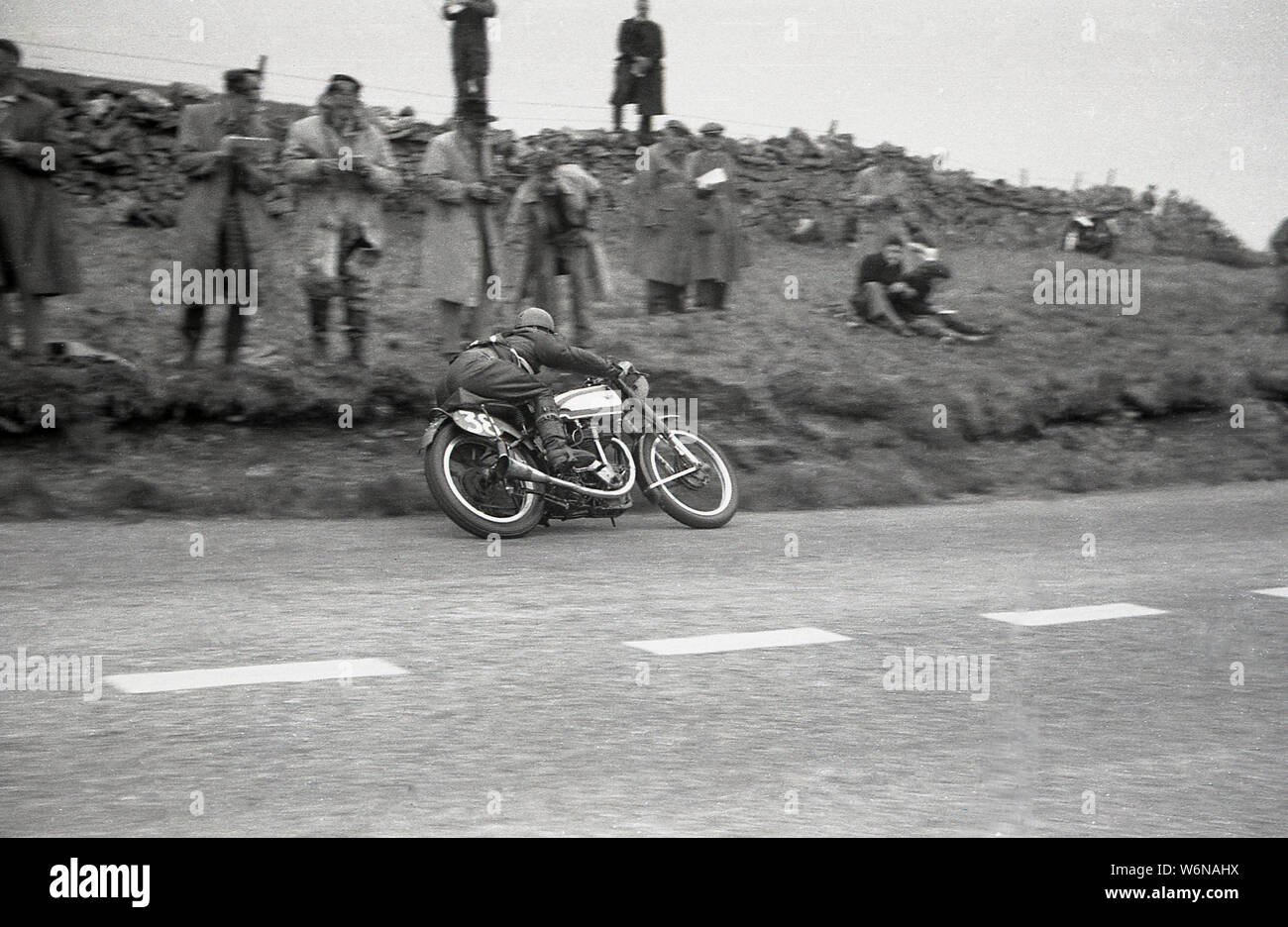 1950s, historical, a motorcyclist riding in the TT race on the Isle of Man. The famous TT (Tourist Trophy) motorcycle races begain in 1907 and are held over the island's public roads, on the Snaefell Mountain Course, although between 1954-1959, the races were on the Cylpse Course with traditional full grid starts. Stock Photo