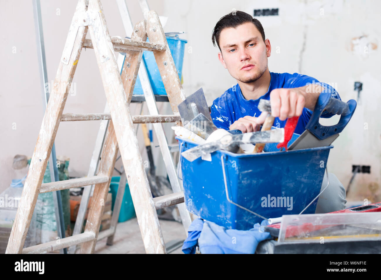 builder handyman choosing necessary tool in toolbox Stock Photo
