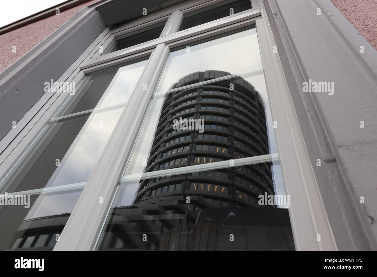 Mirroring of the BIS-Tower, headquarter of the Bank for International Settlements in Basel, Switzerland Stock Photo