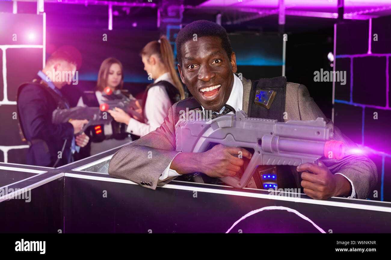 African American man in a business suit holding the laser gun and playing  laser tag with his associates Stock Photo - Alamy