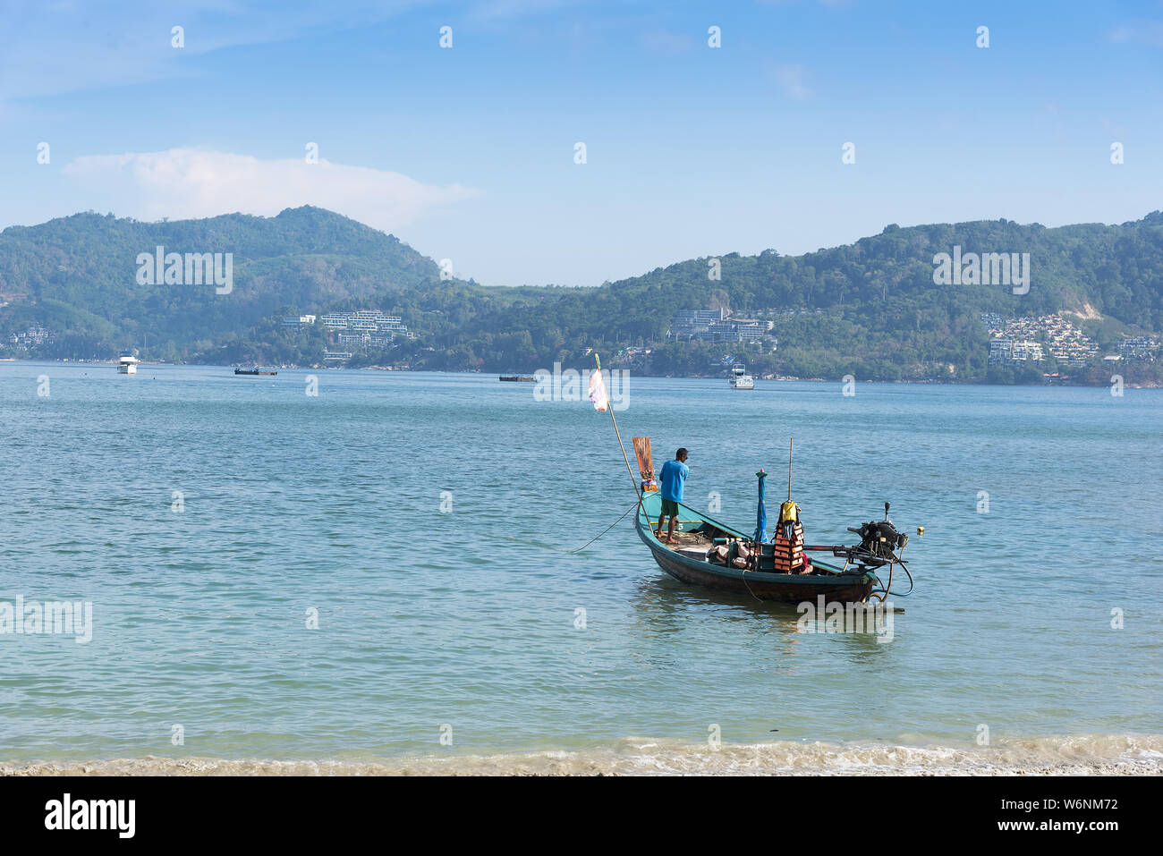 Phuket, Thailand, Patong Beach, 04/19/2019: looking over the sea towards a mainland with fishing boat in foreground. Stock Photo