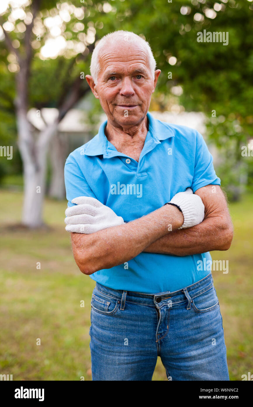 Elderly gardener posing in his garden Stock Photo - Alamy