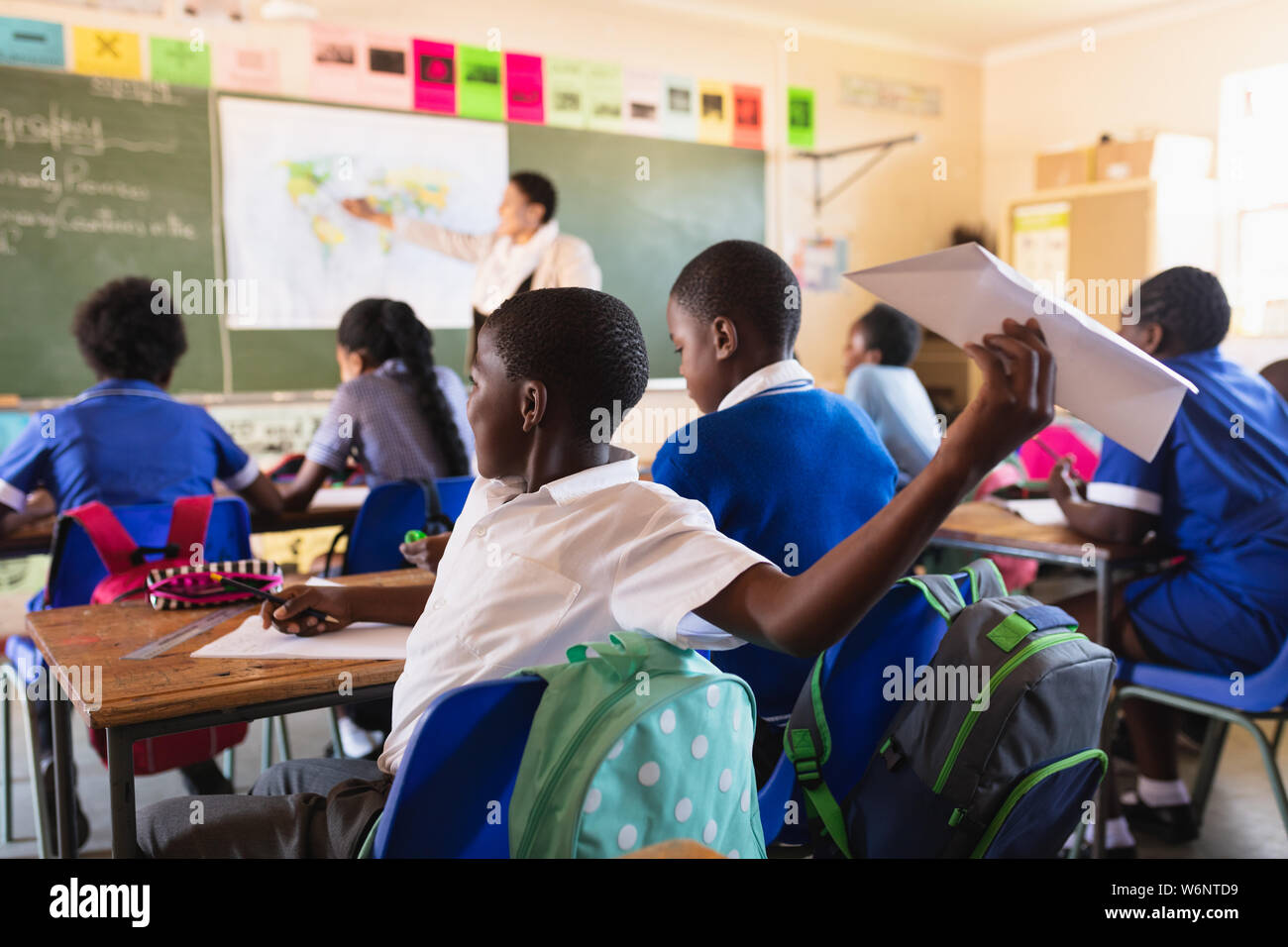 Schoolcboy throwing paper dart in a lesson at a township school Stock