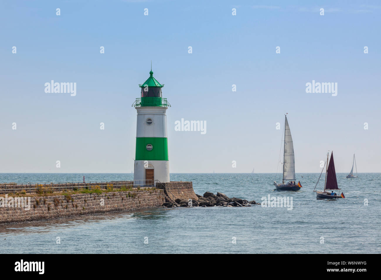 Sailboats passing by Schleimünde lighthouse between Schlei inlet and Baltic Sea Stock Photo