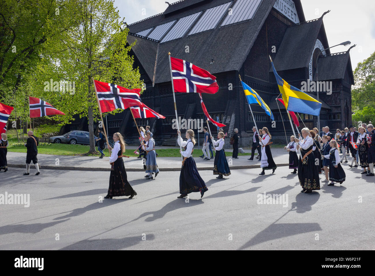 Norwegian patriots holding national flags during the yearly Norways' independence day events near Skansen park's entrance. Scandinavia, Sweden Stock Photo