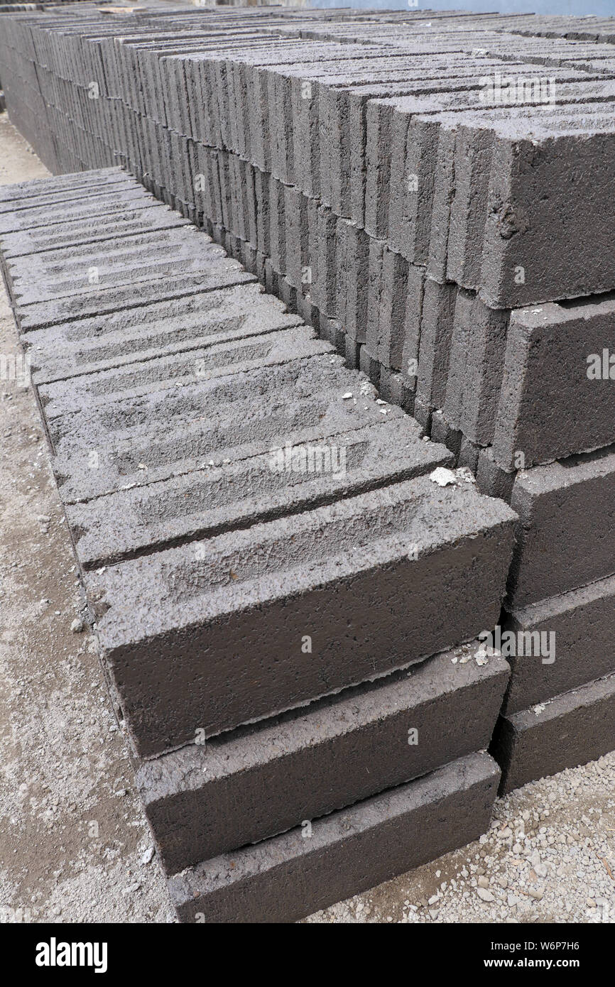 Handmade bricks made of black volcanic sand, water and cement. Manual production on Bali island, Indonesia. The process of sun-drying Stock Photo