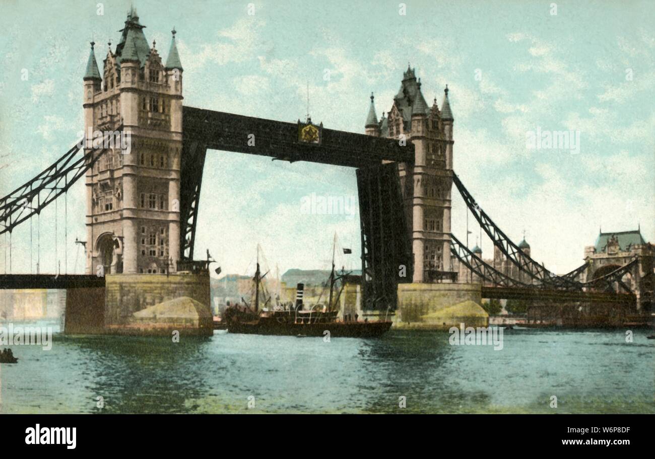 Tower Bridge, London, 1906. View of Tower Bridge over the River Thames, with a ship passing under the raised bascules. The construction of the bridge was begun in 1881 to designs by Sir Horace Jones and it opened in 1894. It was designed so that the central section could be raised to allow the passage of ships to and from the busy wharves of London. Postcard. Stock Photo