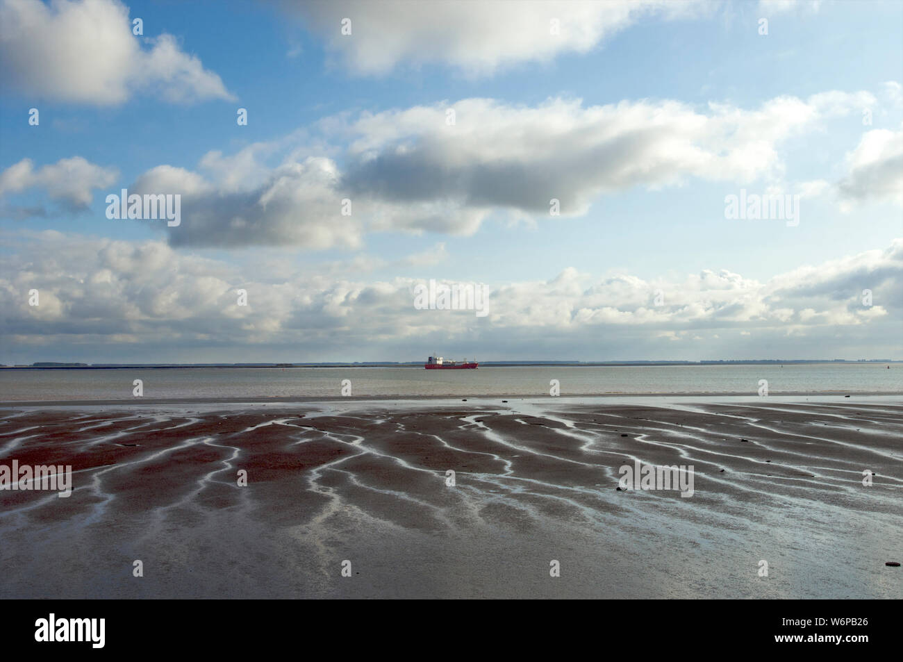 Low tide with sandbars visible at the Wester Schelde while a tankership